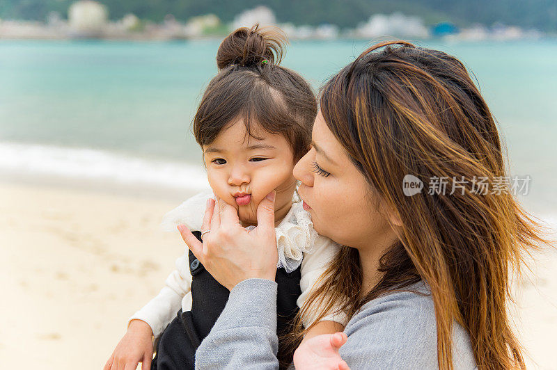 妈妈和小女孩在海滩上玩