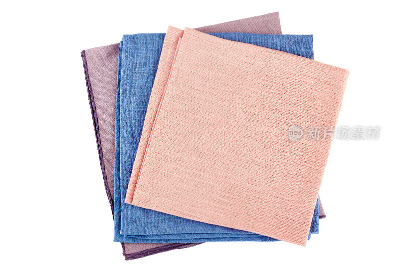 三张彩色的餐巾叠在白色的纸上