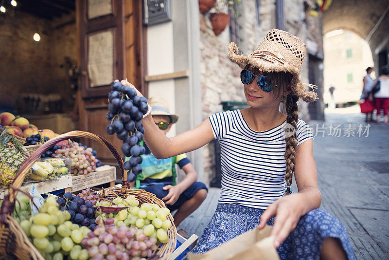 小女孩在意大利蔬菜水果店买水果