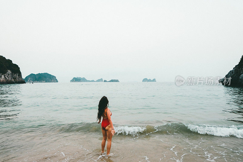 一个女人在越南的海滩上遇见日落