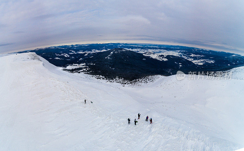 冬季滑雪者在山顶。无人驾驶飞机在喀尔巴阡山脉飞行。