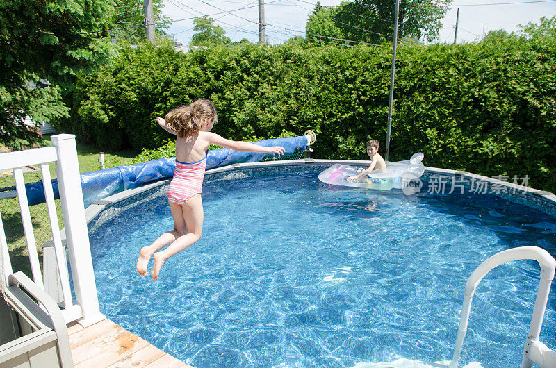 夏天的一天，女孩在游泳池里蹦蹦跳跳，而她的弟弟正在充气泳池床垫上休息