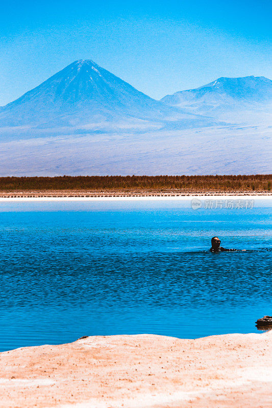 在智利阿塔卡马沙漠的美丽湖泊里，一名男子在玩耍。