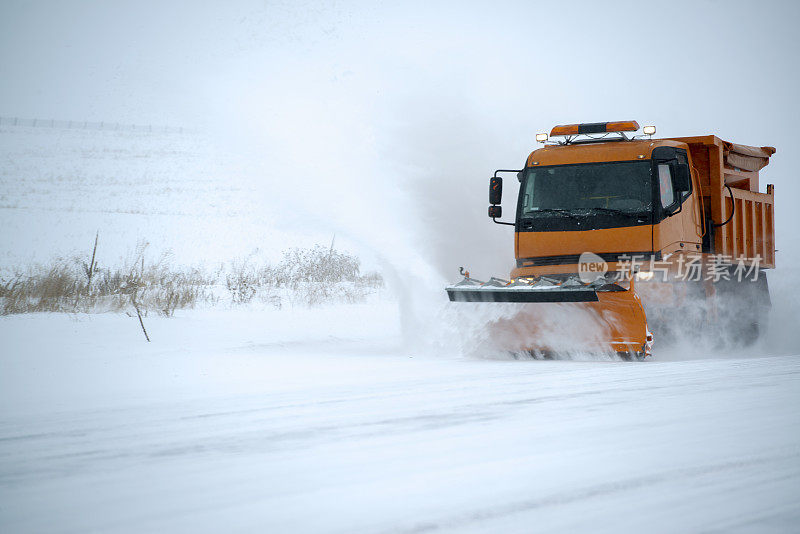 扫雪机清理了被雪覆盖的结冰的道路