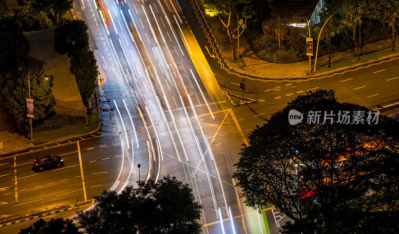 新加坡道路交汇处，夜间从上面的车流中透出灯光