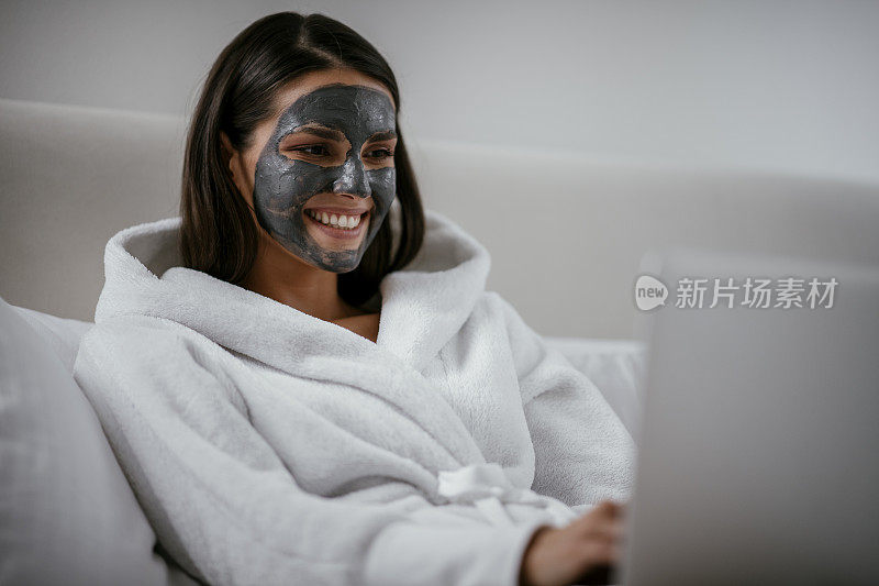 小女孩戴着净化黑脸面具使用电脑