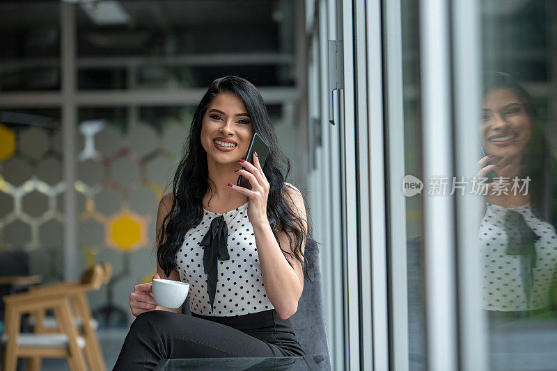 性感的女性商务女性在她的电话交谈。