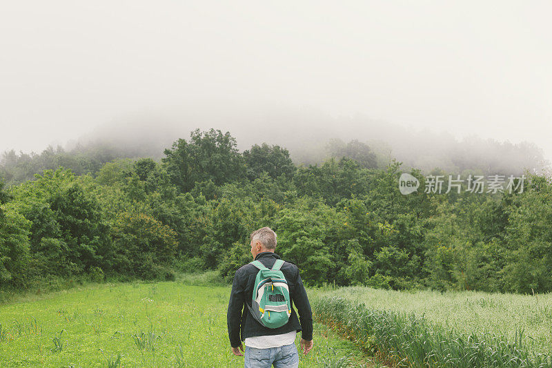 在下雨的春日在山上徒步旅行