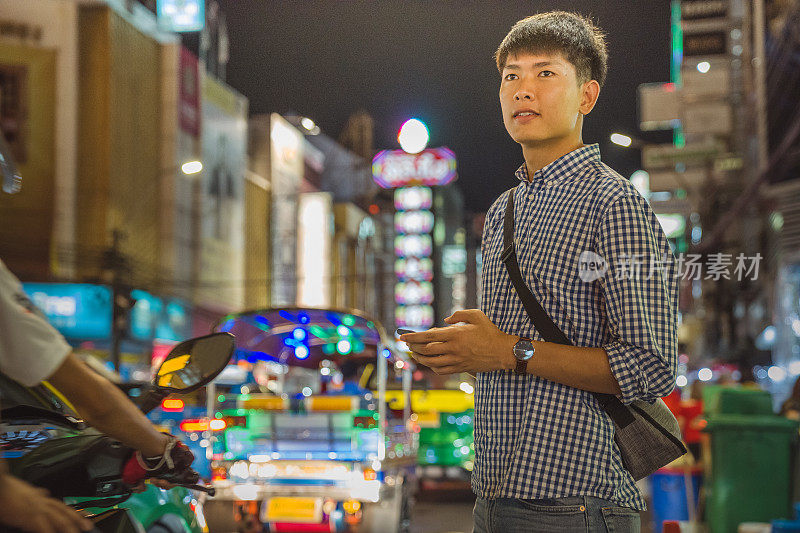 年轻的亚洲男人喜欢在泰国曼谷的中国城Yaowarat街旅游