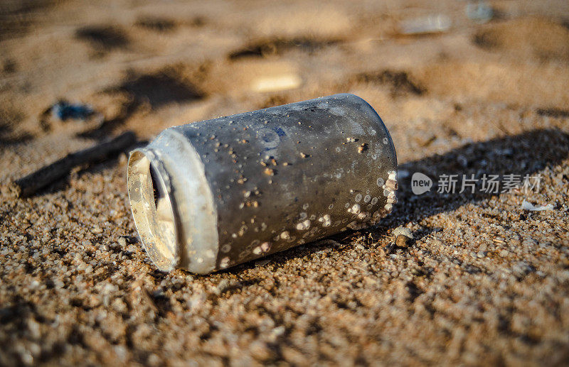 垃圾啤酒罐被冲到泰国沙塔希区的海滩上
