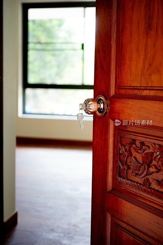房子钥匙插在木门的钥匙孔里
