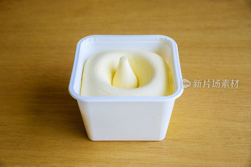 塑料容器装有打发的奶油黄油。