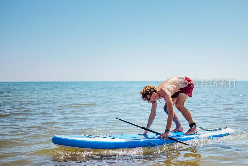 年轻人paddleboarding