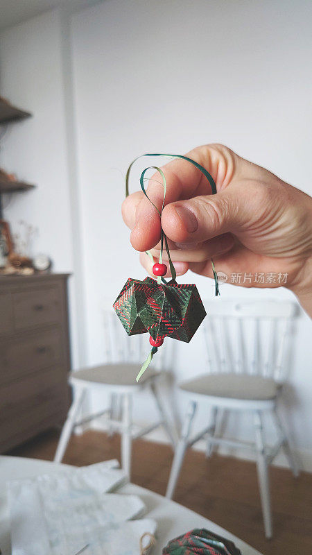 成熟女子手持纸折纸装饰圣诞树，特写