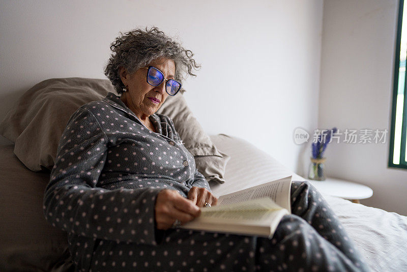 退休妇女在她的房间里看书休息