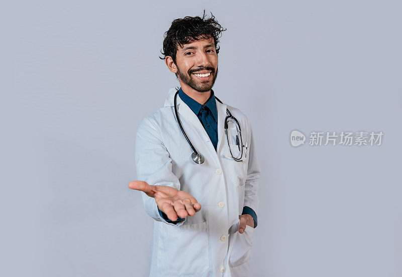 微笑的医生伸出手欢迎。年轻的医生伸出手对着镜头，微笑的医生伸出手孤立