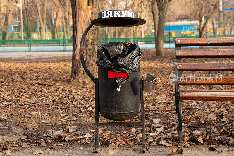 秋天的乌克兰第聂伯罗市，公园垃圾桶旁的长椅上，乌克兰语中有“谢谢”一词