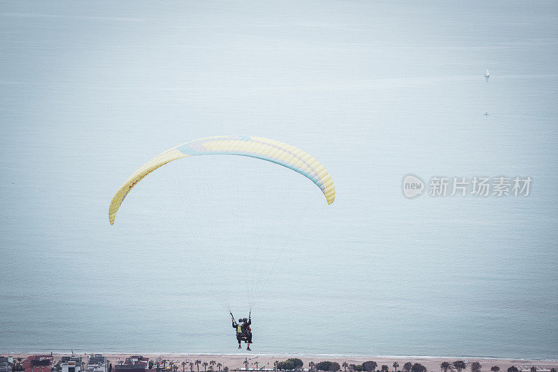 在空中滑翔。滑翔伞飞过碧水青山的大海