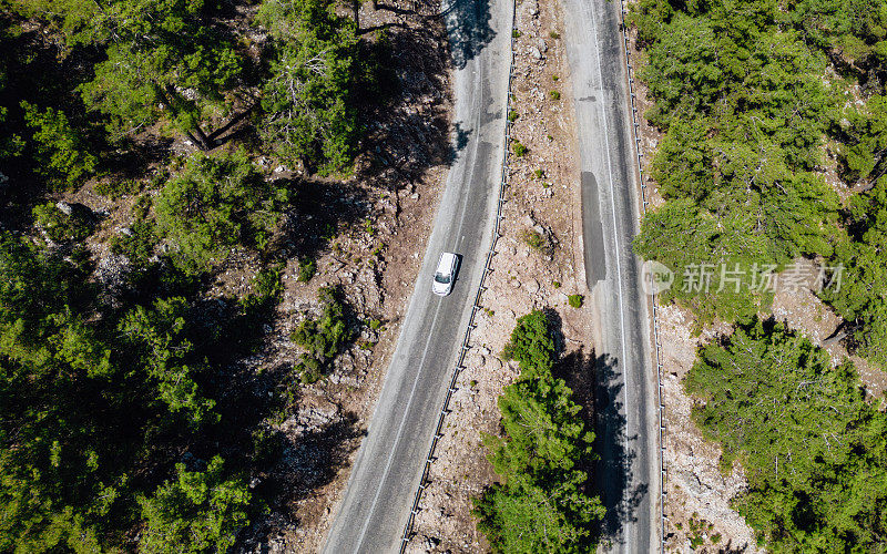 在森林山区的道路上行驶的车辆用无人机拍摄沥青弯道