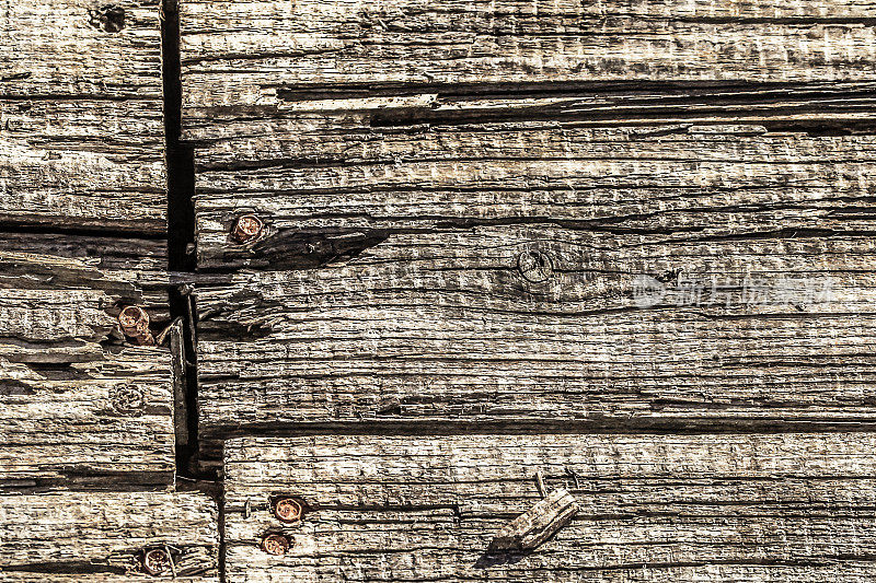 旧风化、腐烂、开裂的松木板，用锈蚀的外六角法兰螺栓固定