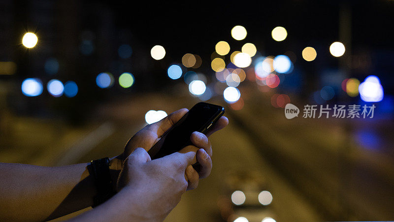 男人的手在晚上用智能手机