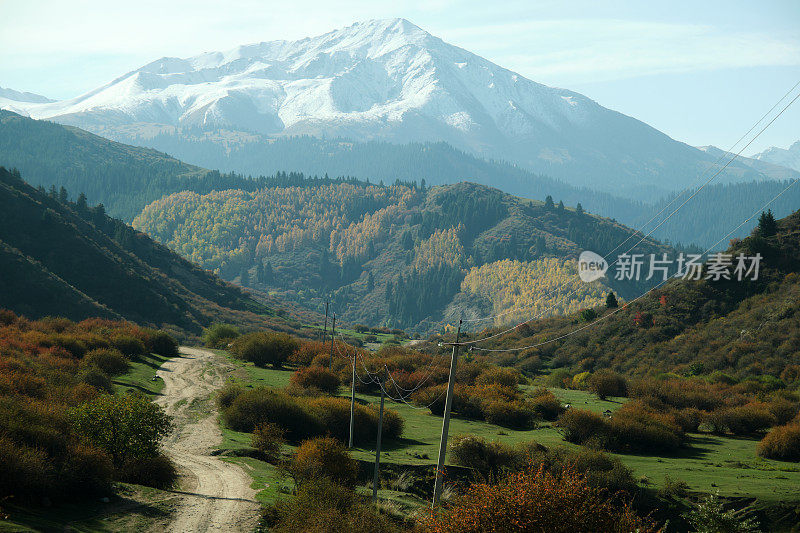 在阳光明媚的秋日里，蜿蜒的土路穿过山峡