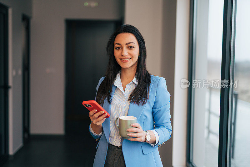 年轻的女商人使用手机和短信