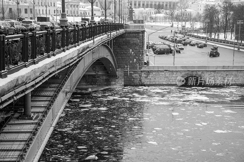 冬季莫斯科河上的冰在克里姆林宫河堤上的大剧院卡门尼桥下漂移。黑色和白色。