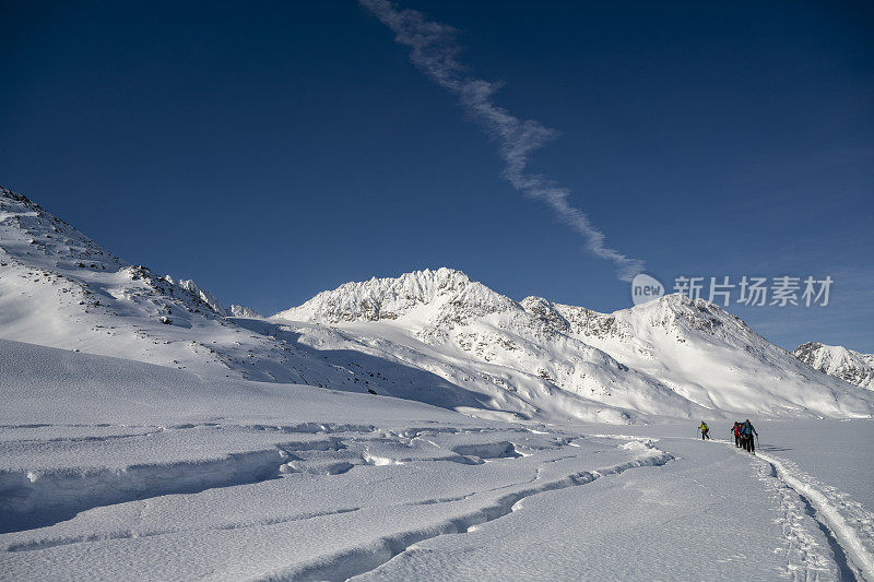 滑雪登山运动员攀登白雪皑皑的山峰