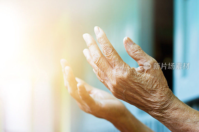 老妇人双手真诚地祈祷着。