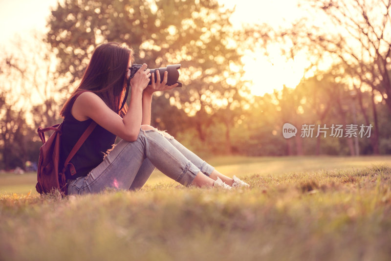 女人是一个带着单反相机的摄影师，户外和阳光。
