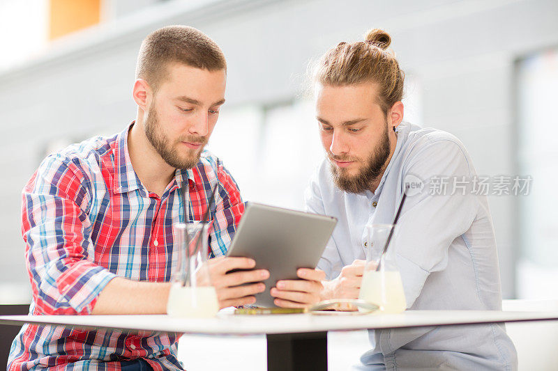 两个年轻人在用平板电脑