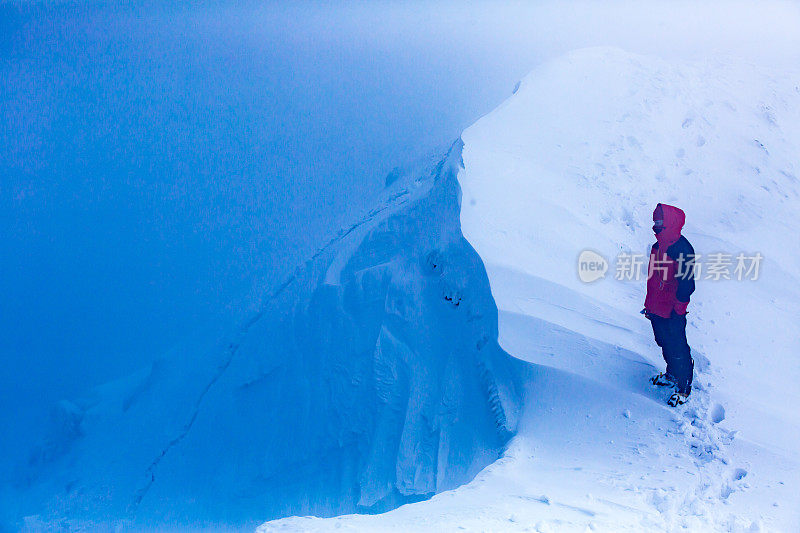 一个人站在白雪覆盖的山峰上