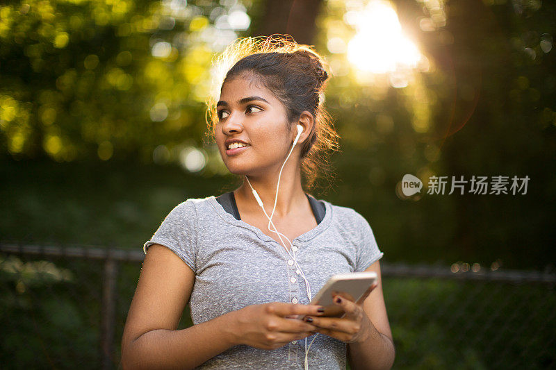 年轻的少数民族妇女在户外听音乐