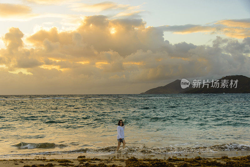 清晨在海滩上散步的女人。