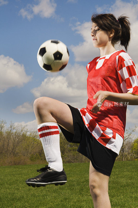 年轻的女孩足球运动员在操场上玩