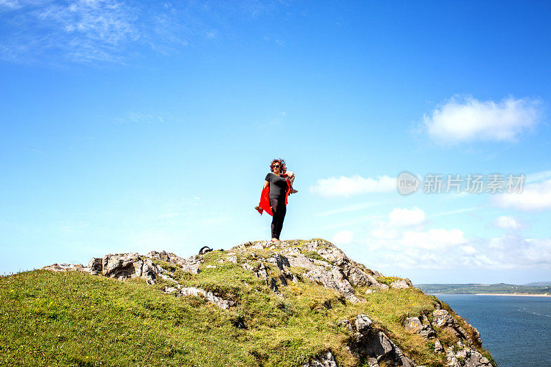 一个成熟的西班牙女人站在遥远的海岸岬角上