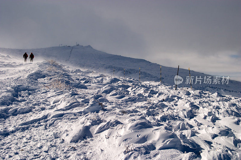 滑雪者在刮风的日子里走来走去