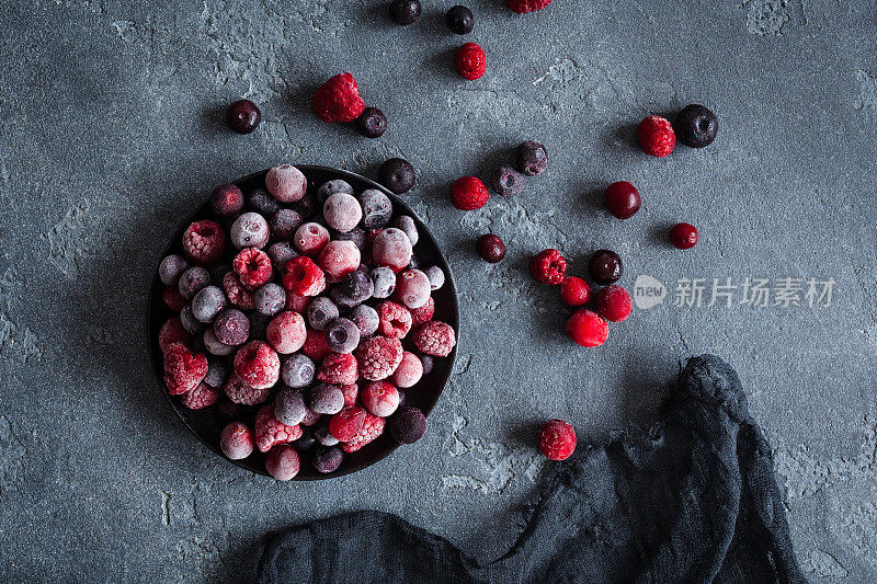 冰冻覆盆子，蓝莓，蔓越莓在黑暗的背景