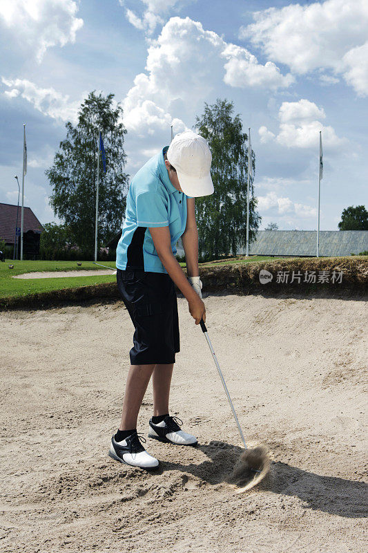 在沙坑里练习高尔夫球