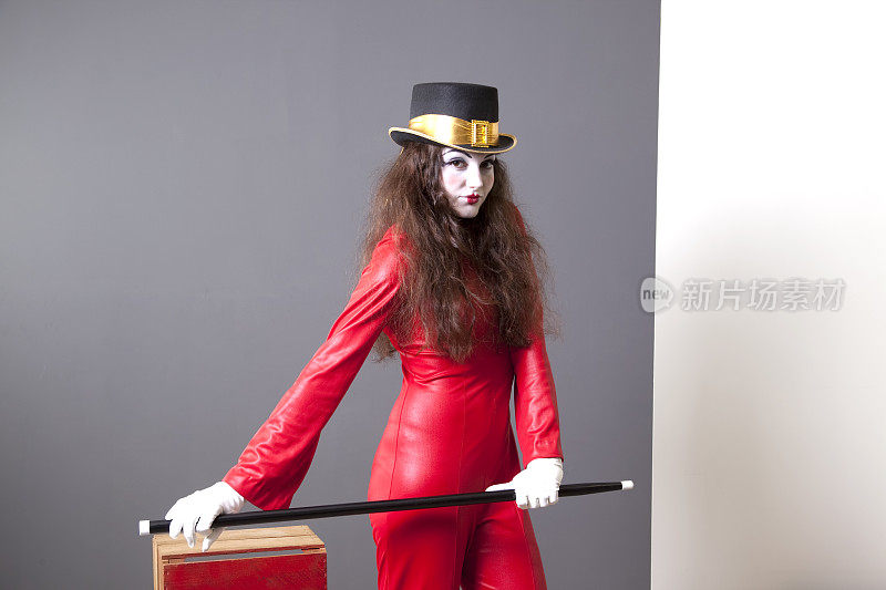 哑剧演员穿着红色套装，高顶礼帽，白手套。舞蹈