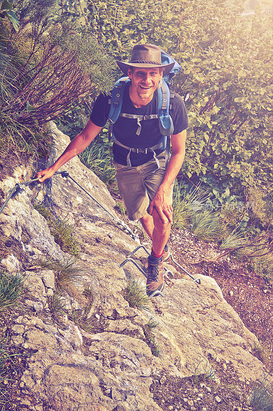 一个冒险家在爬山时看着摄像机