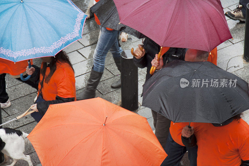 街上的人们撑着五颜六色的伞。