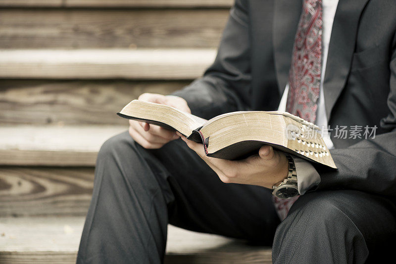 传教士坐在楼梯上读圣经