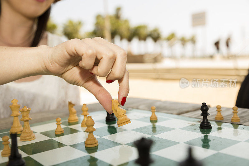 游戏:女子在圣塔莫尼卡的国际象棋公园玩游戏