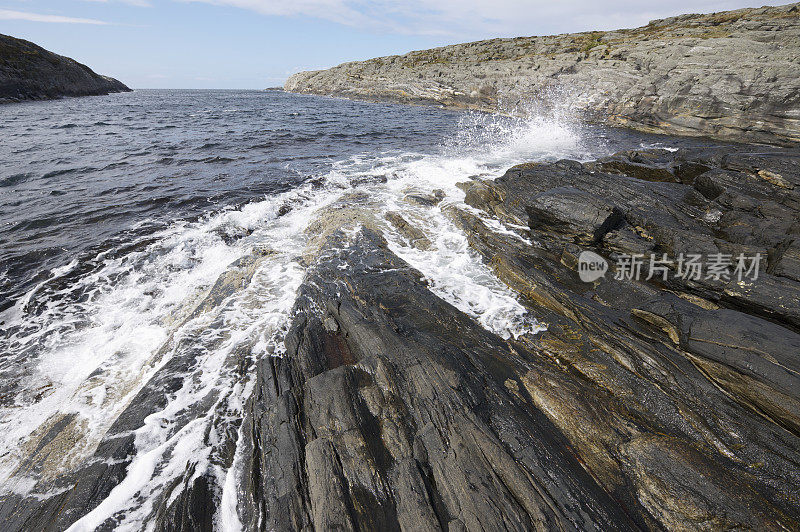 在岩石密布的挪威海岸掀起的波浪