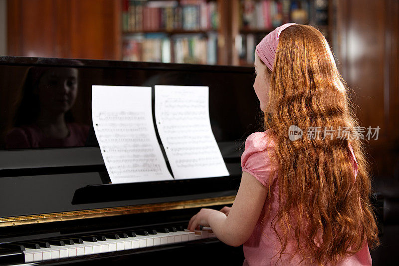 年轻女孩在弹钢琴