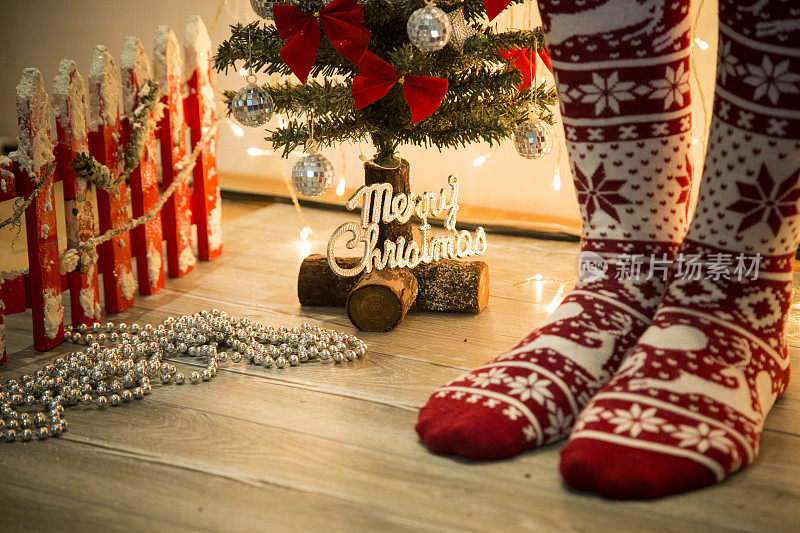 女人的腿在冬季的袜子由圣诞装饰