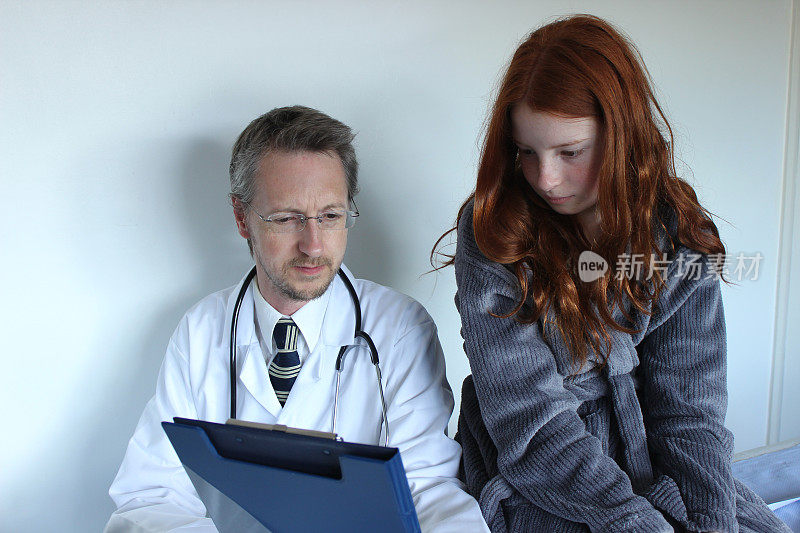 医院医生在他的写字板上给一个女病人看便条