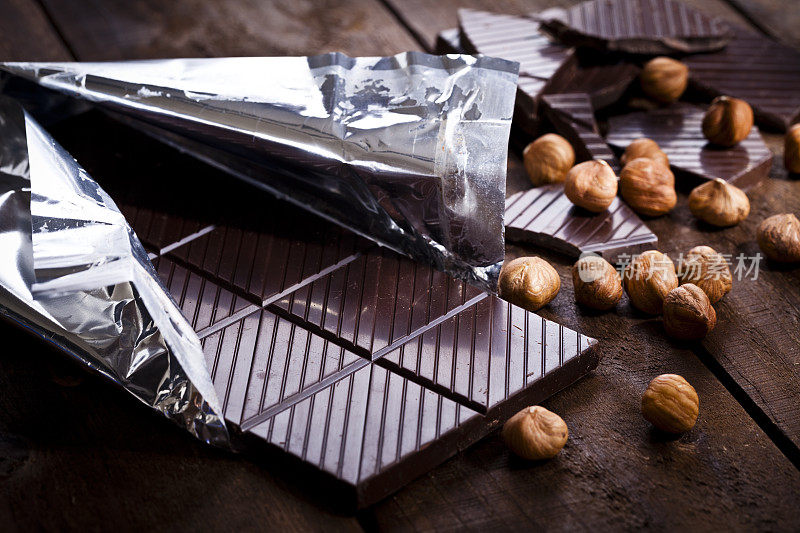质朴的木桌上放着巧克力和榛子